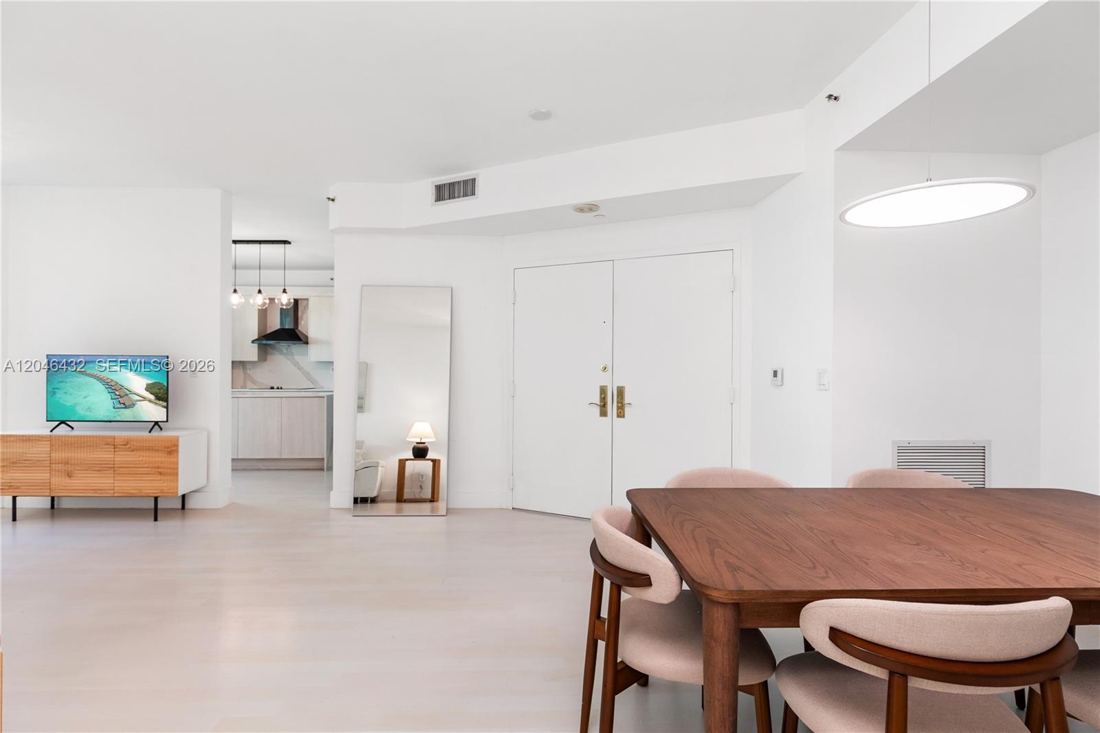 A bright, open-concept living and dining area features white walls, light flooring, and modern furniture — 300 S Pointe Dr # 907, Miami Beach FL 33139, MIAMI BEACH, FL