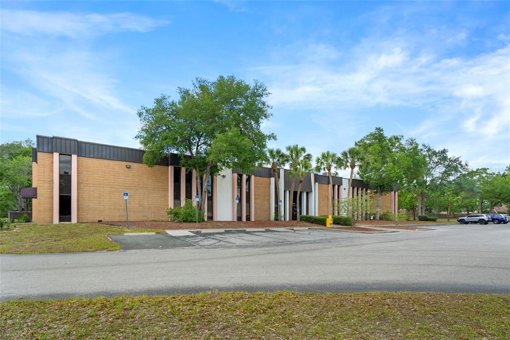 A single-story commercial building with tan brick walls and a flat roof sits near parking — 1624 N MEADOWCREST BOULEVARD UNIT 3, CRYSTAL RIVER, FL