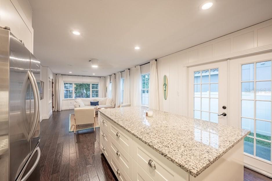 A kitchen island with granite countertops sits in a bright room with dark wood floors — 1837 WORRINGTON STREET, SARASOTA, FL