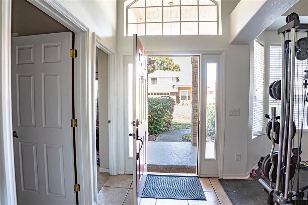 An entryway with tile flooring, an open front door, and a home gym area — 1400 BENT OAKS BOULEVARD, DELAND, FL