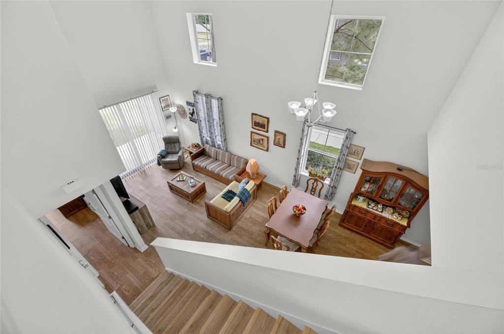 A high-angle view shows a living and dining area with wood floors and vaulted ceilings — 2130 BROADWAY VIEW AVENUE, BRANDON, FL