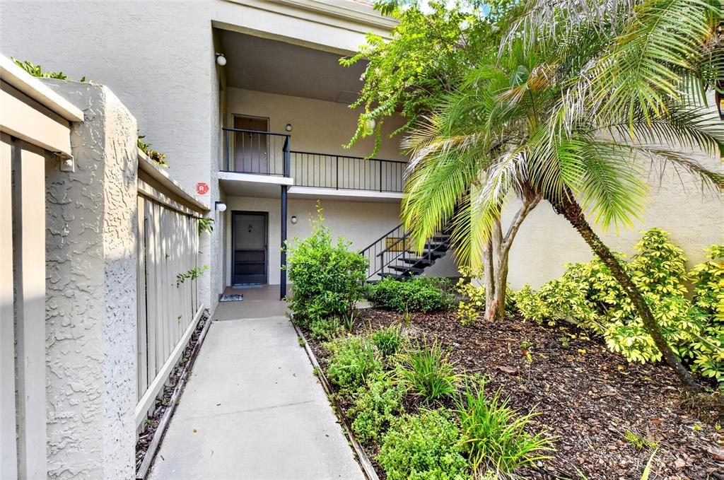 An exterior view of a two-story apartment building with a walkway and staircase — 3272 S SEMORAN BOULEVARD UNIT 11, ORLANDO, FL