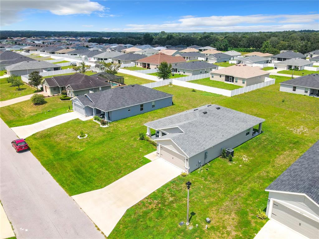 An aerial view shows several suburban single-family homes with gray roofs and green lawns — 5541 SE 92ND STREET, OCALA, FL