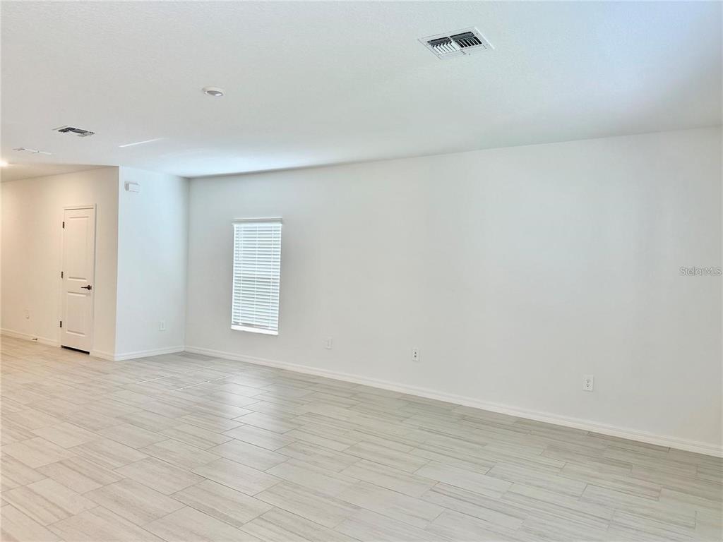 An empty room with white walls, light-colored tile flooring, and a single window with blinds — 17606 HAPPYTRAILS STREET, LAND O LAKES, FL