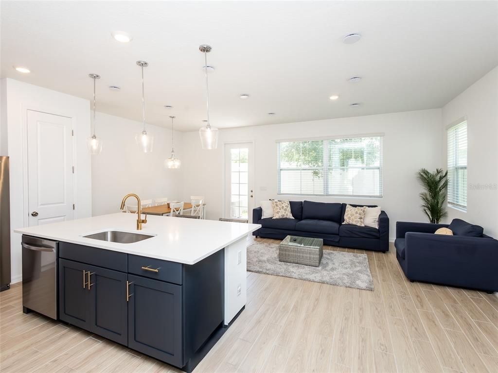 A kitchen with a dark blue island and white countertops opens into a living area — 783 LONGBOAT DRIVE, DAVENPORT, FL