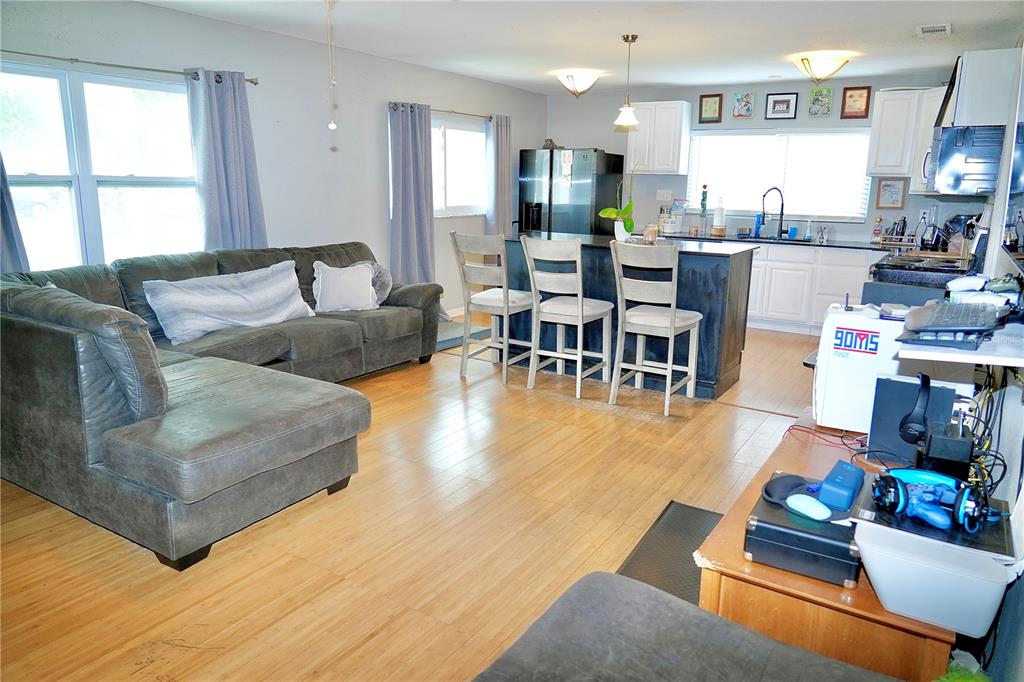 A living room with a sectional sofa flows into an open kitchen with an island — 1513 W PATTERSON STREET, TAMPA, FL