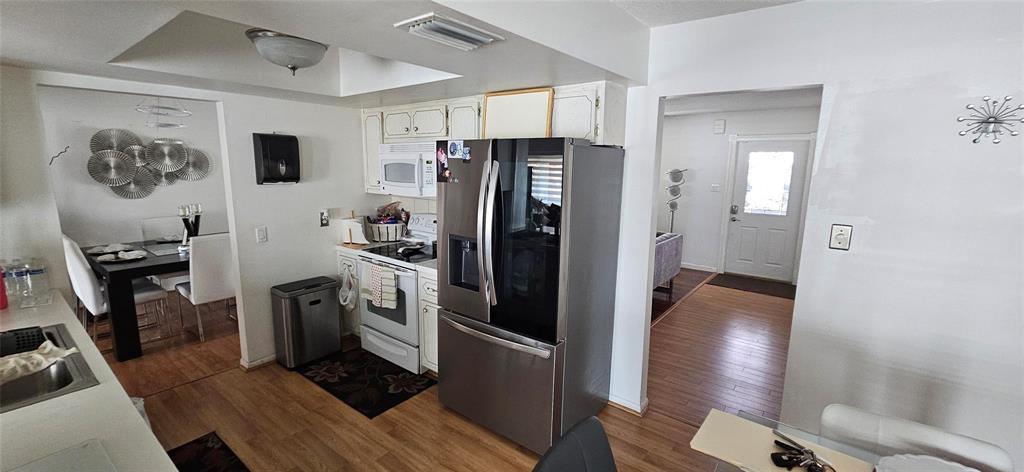A kitchen with stainless steel appliances opens into a dining area and an entryway — 7000 NW 11th Street, Margate FL 33063, MARGATE, FL