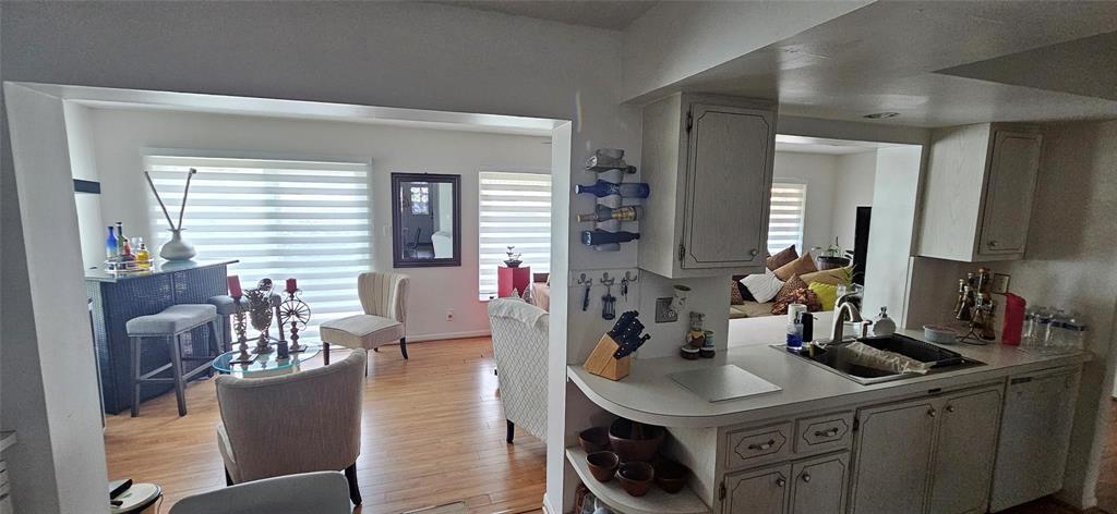 A kitchen with light-colored cabinets overlooks an open-concept living and dining area — 7000 NW 11th Street, Margate FL 33063, MARGATE, FL