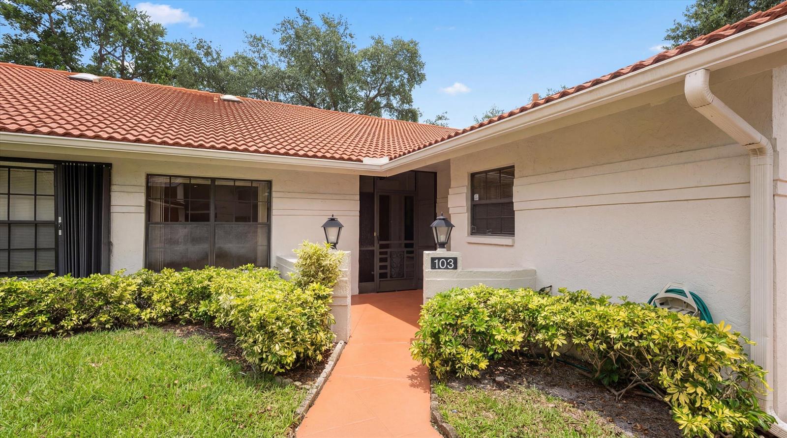 A walkway leads to the front entrance of a single-story home with a tiled roof — 9832 Pavarotti Terrace # 103, Boynton Beach FL 33437, BOYNTON BEACH, FL