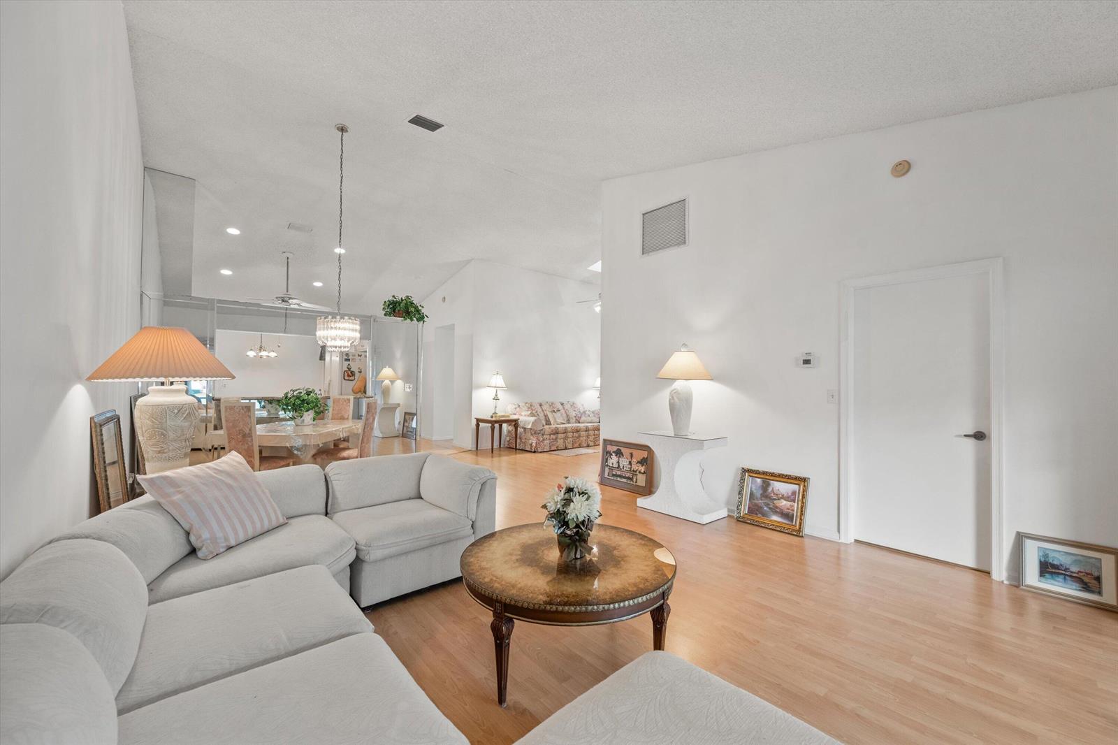 A living room with light wood floors, a sectional sofa, and a round coffee table — 9832 Pavarotti Terrace # 103, Boynton Beach FL 33437, BOYNTON BEACH, FL