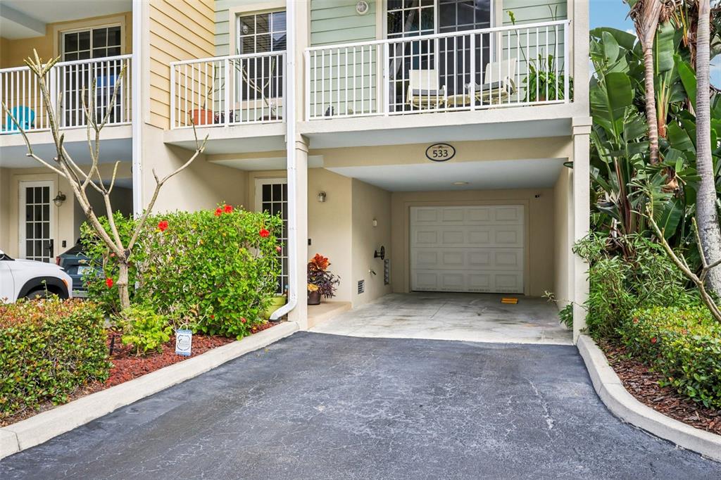 The exterior view shows a multi-story townhouse with a ground-level garage and a second-floor balcony — 533 BAHIA BEACH BOULEVARD, RUSKIN, FL