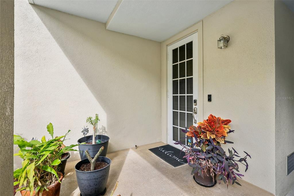 An exterior entryway features a white door with glass panels, a welcome mat, and potted plants — 533 BAHIA BEACH BOULEVARD, RUSKIN, FL