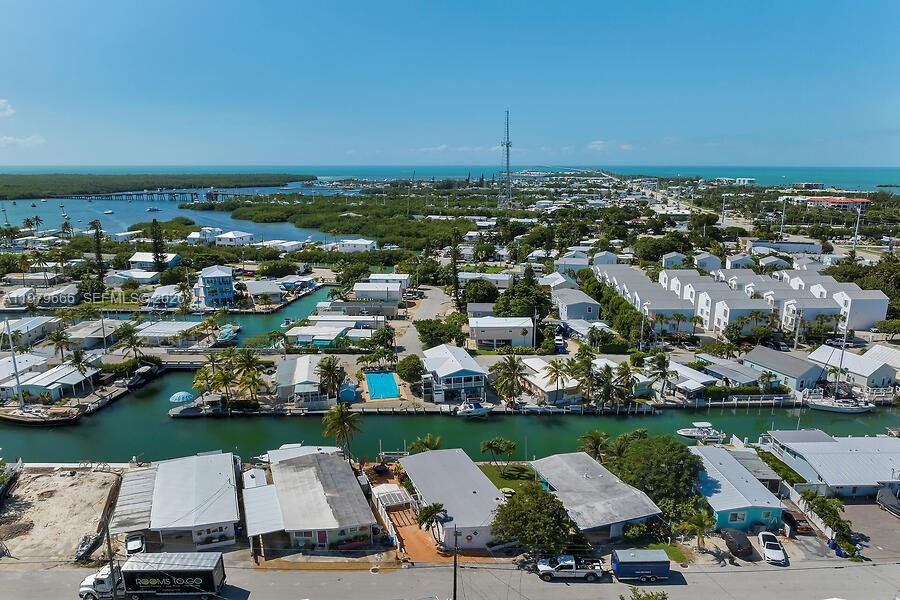 An aerial view shows a coastal neighborhood with houses, canals, and boats under a blue sky — 605 26th Street Ocean, Marathon FL 33050, MARATHON, FL