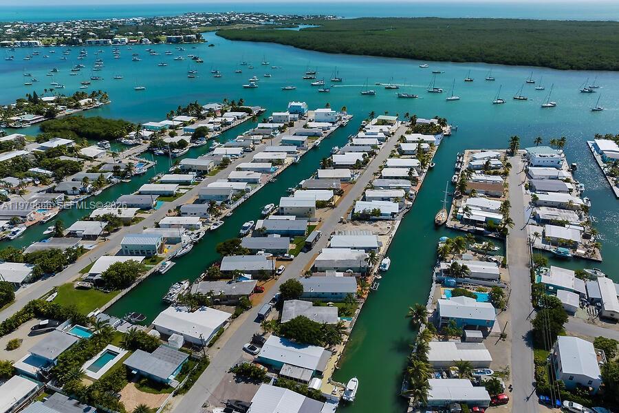 An aerial view shows rows of waterfront homes along canals leading to a large bay — 605 26th Street Ocean, Marathon FL 33050, MARATHON, FL