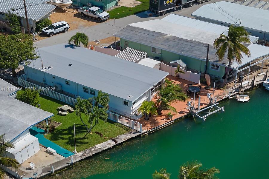 An aerial view shows a waterfront house with a metal roof and a boat lift — 605 26th Street Ocean, Marathon FL 33050, MARATHON, FL