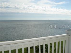 A white railing overlooks a large body of water under a cloudy sky — 5248 BEACH DRIVE SE UNIT 5248, ST PETERSBURG, FL