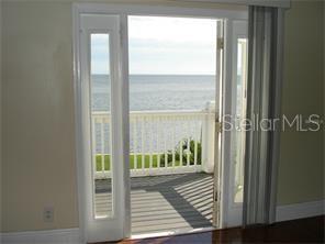 A room with a white door opening onto a wooden deck overlooking the ocean — 5248 BEACH DRIVE SE UNIT 5248, ST PETERSBURG, FL