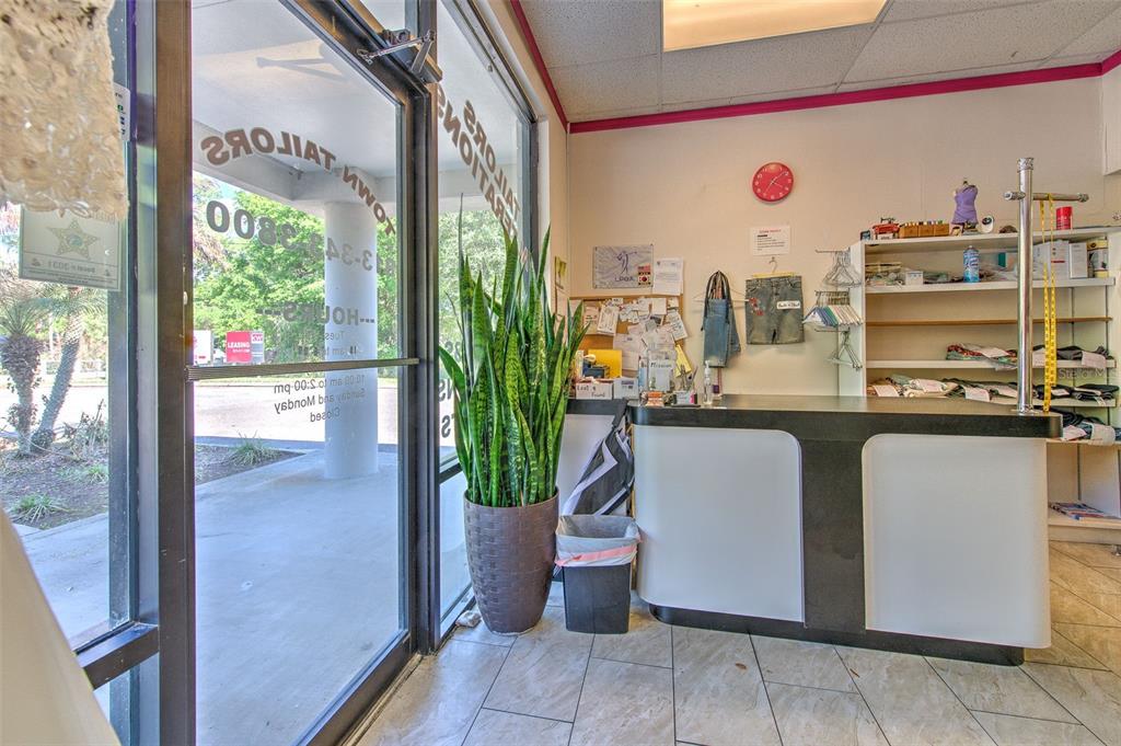 A small tailor shop features a service counter, a large potted plant, and glass doors — 3662 LITHIA PINECREST ROAD, VALRICO, FL