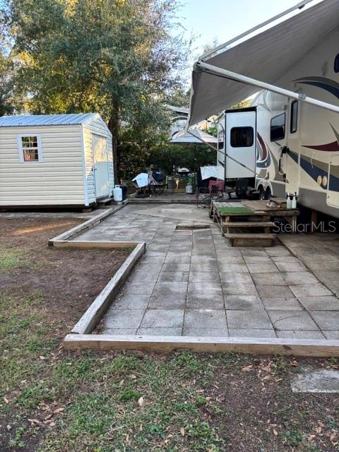 An outdoor patio area features a paved surface, a storage shed, and a parked RV — 14348 NE 252ND COURT ROAD, FORT MC COY, FL