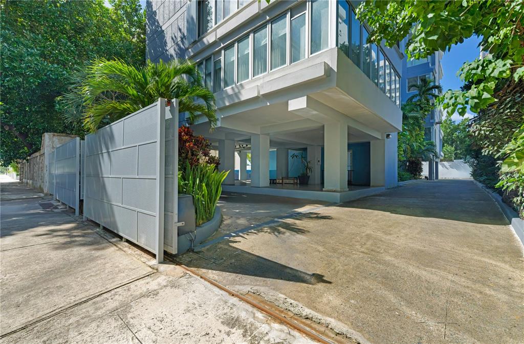 A view of a building exterior with a covered parking area and a metal fence — 8 MANUEL RODRIGUEZ SERRA STREET UNIT 2B, SAN JUAN, PR