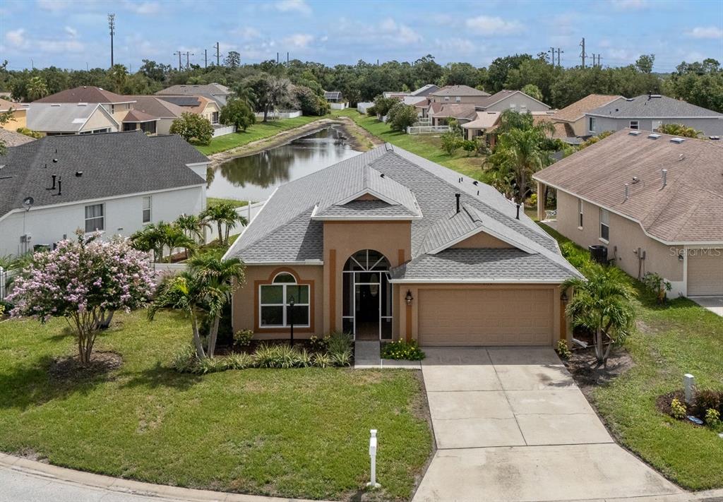 An aerial view of a tan single-story house with a gray roof and concrete driveway — 4124 101ST AVENUE E, PARRISH, FL