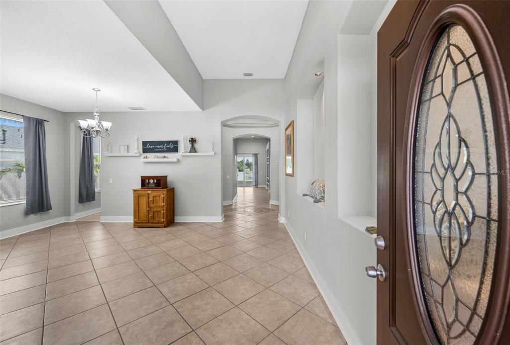A tiled entryway leads into a living area with a chandelier and arched hallway — 4124 101ST AVENUE E, PARRISH, FL