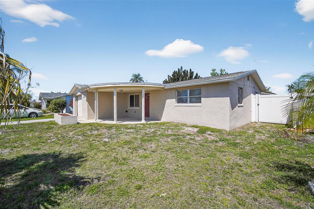 A single-story house with a curved front porch and a white vinyl fence — 3537 SEFFNER DRIVE, HOLIDAY, FL
