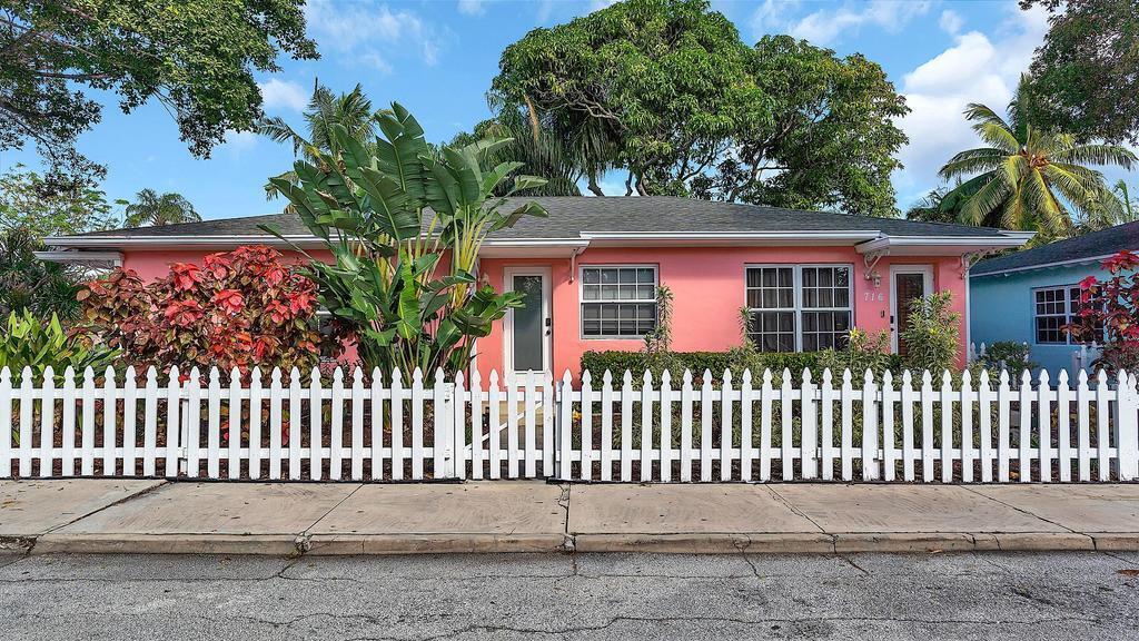 A pink single-story house with a white picket fence and tropical landscaping — 802 N J Street, FL 33460, FL