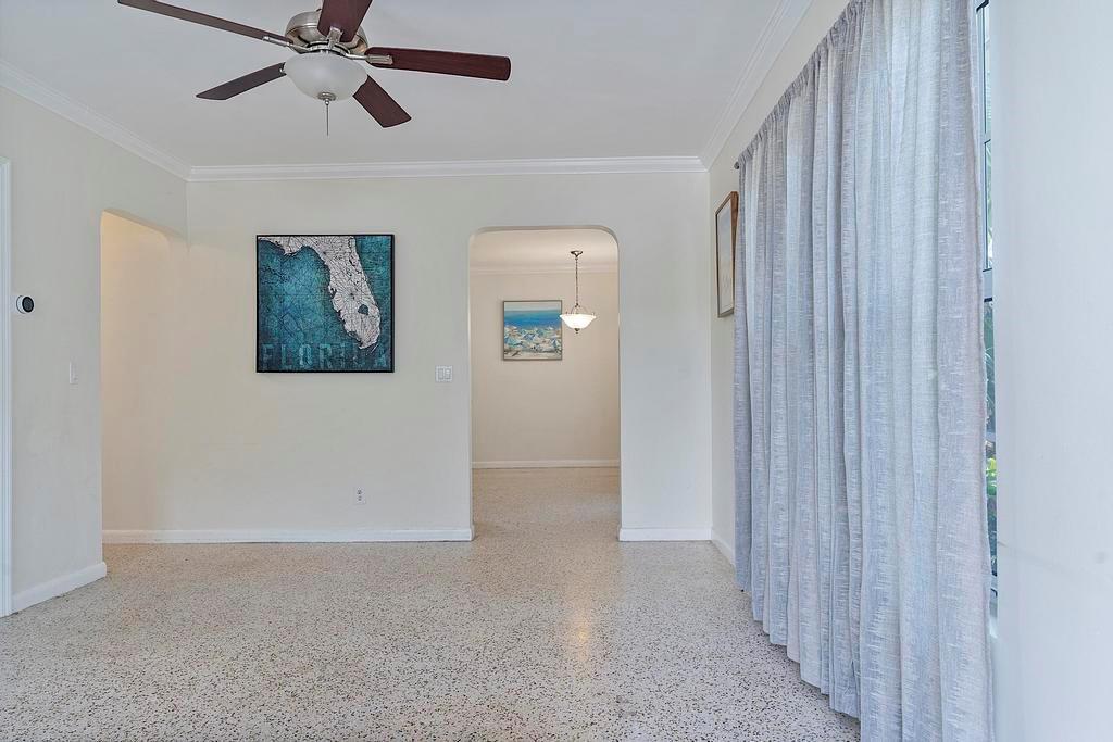 A living room features terrazzo flooring, a ceiling fan, and an arched doorway to another room — 802 N J Street, FL 33460, FL