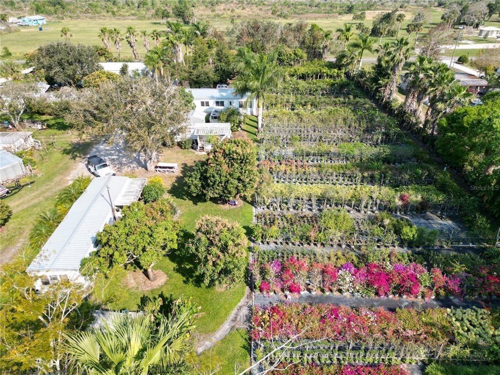 An aerial view shows a house with a large plant nursery and colorful flowering shrubs — 3321 38th Avenue, Okeechobee FL 34974, OKEECHOBEE, FL