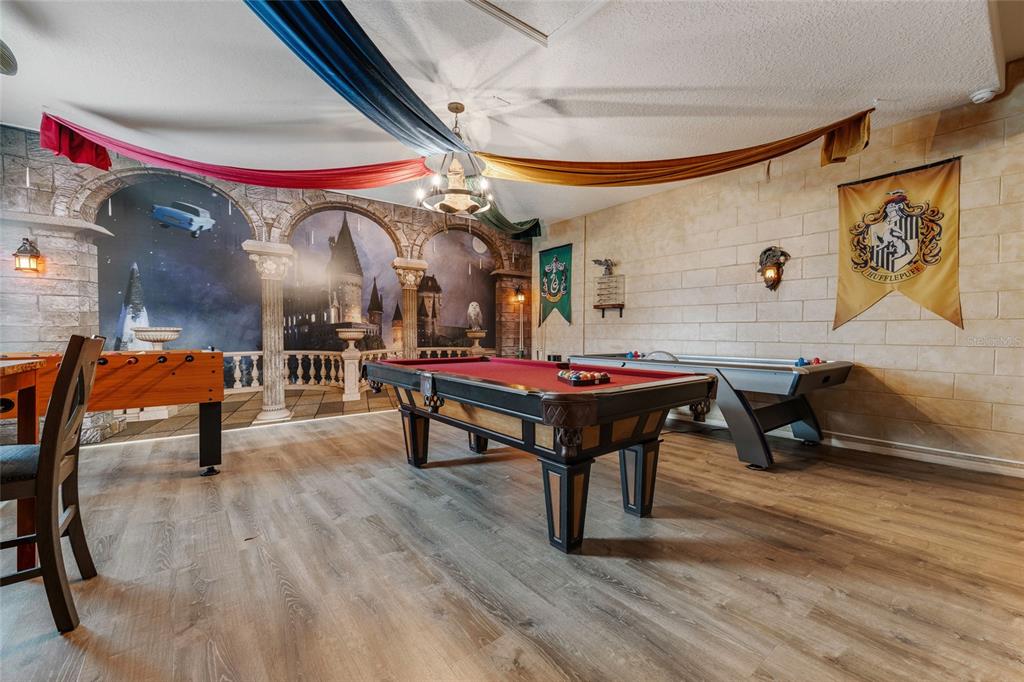 A Harry Potter-themed game room features a pool table, foosball table, and wall murals — 4115 OAKTREE DRIVE, DAVENPORT, FL