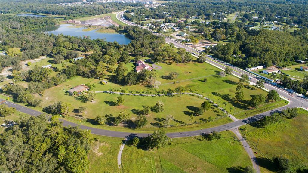 An aerial view shows a large grassy lot with two houses, trees, and a pond — 3440 BOGGY CREEK ROAD, KISSIMMEE, FL