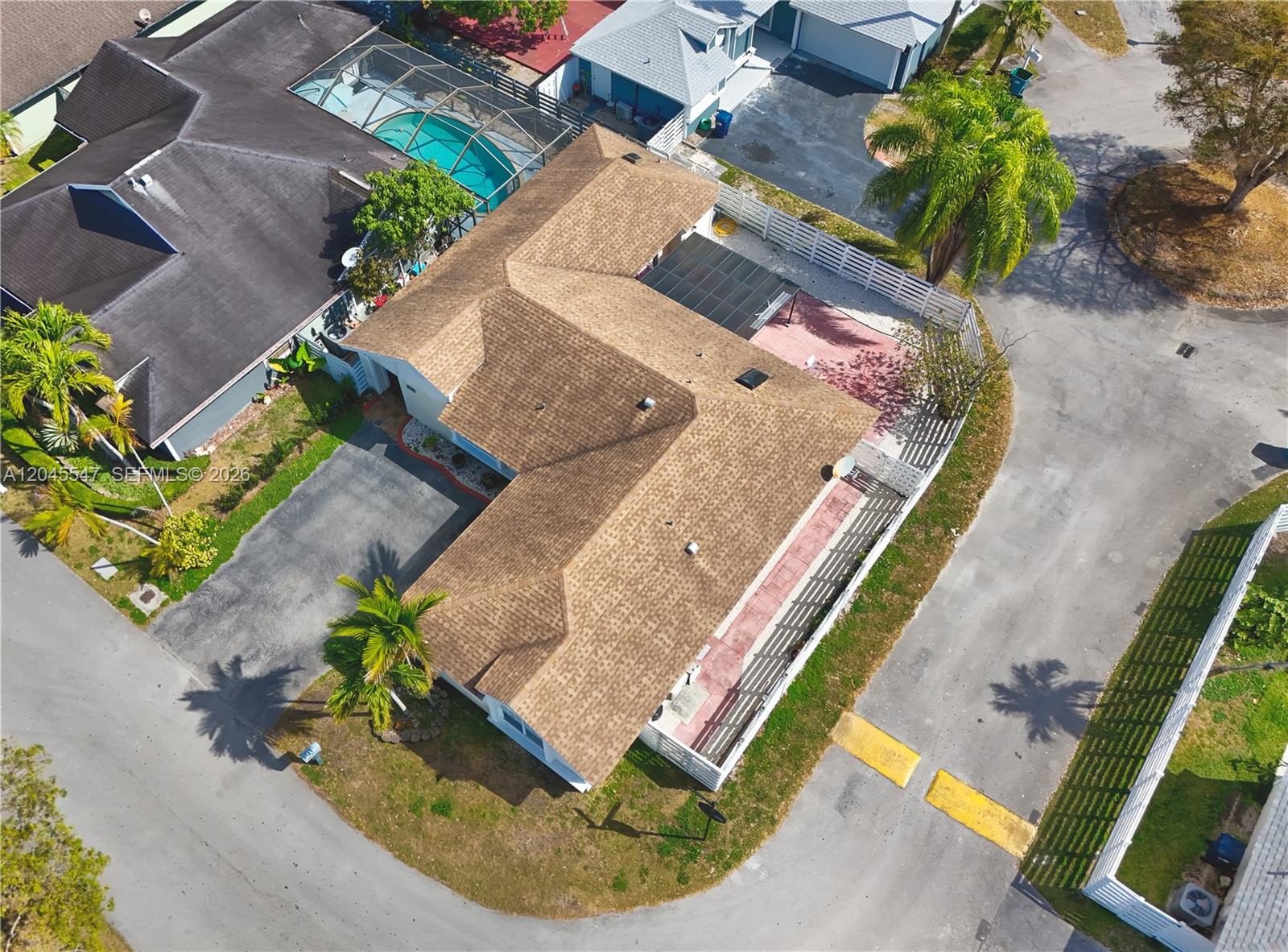 An aerial view shows a single-story house with a brown shingled roof and a fenced yard — 10125 SW 139th Pl, Miami FL 33186, MIAMI, FL