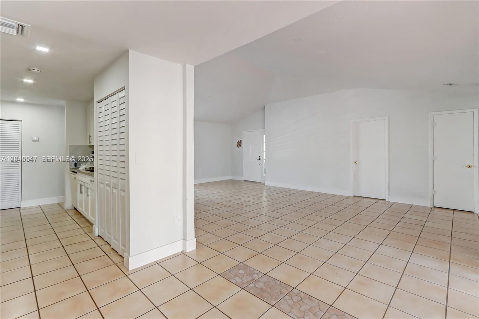 An open-concept living area features light-colored tile flooring and white walls — 10125 SW 139th Pl, Miami FL 33186, MIAMI, FL