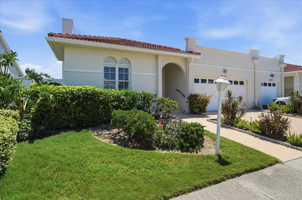 A single-story stucco villa with a red tile roof, arched entryway, and attached garage — 4904 61ST AVENUE TERRACE W, BRADENTON, FL