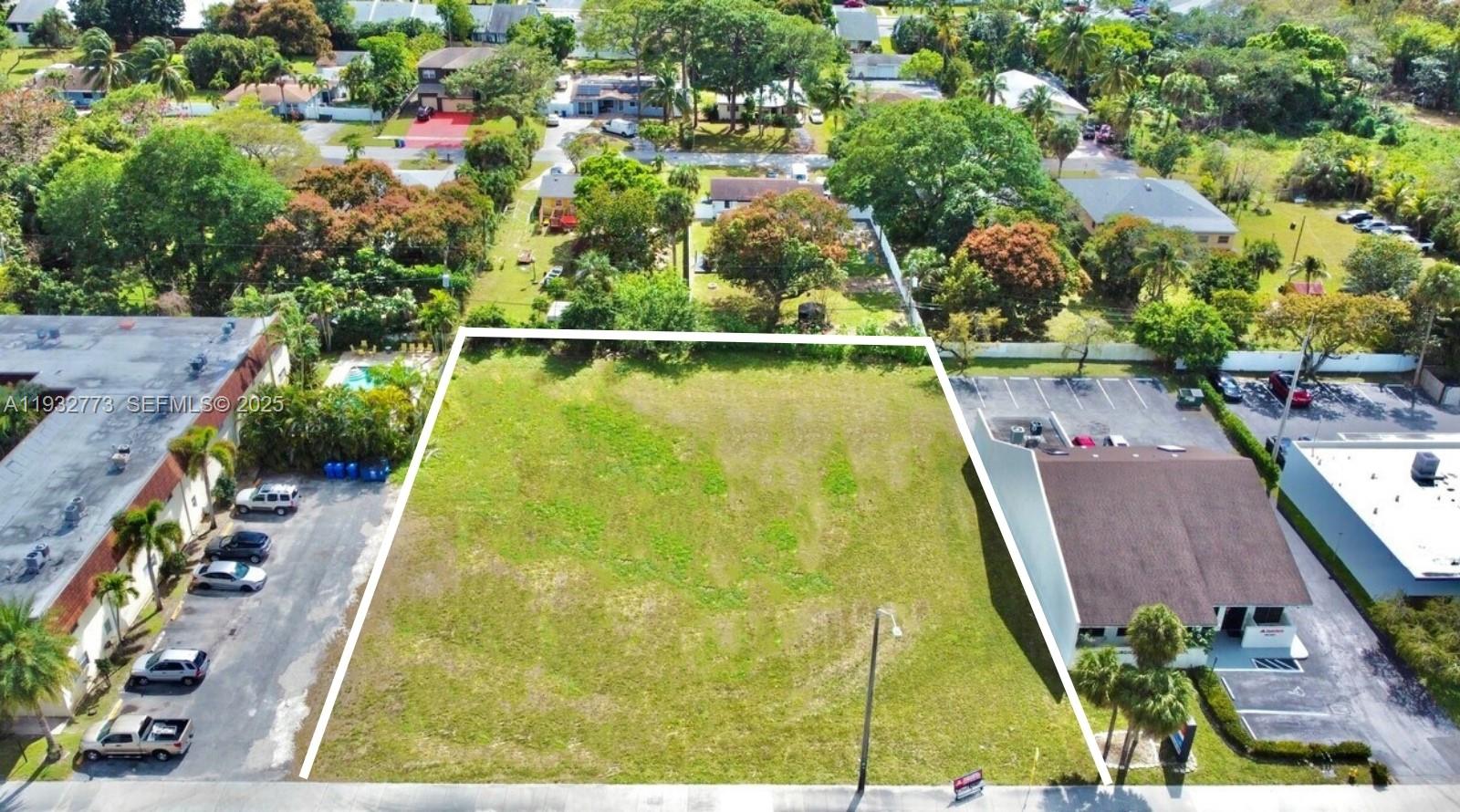 An aerial view shows a vacant, rectangular grassy lot situated between two commercial buildings — 6200 W Atlantic Blvd, Margate FL 33063, MARGATE, FL