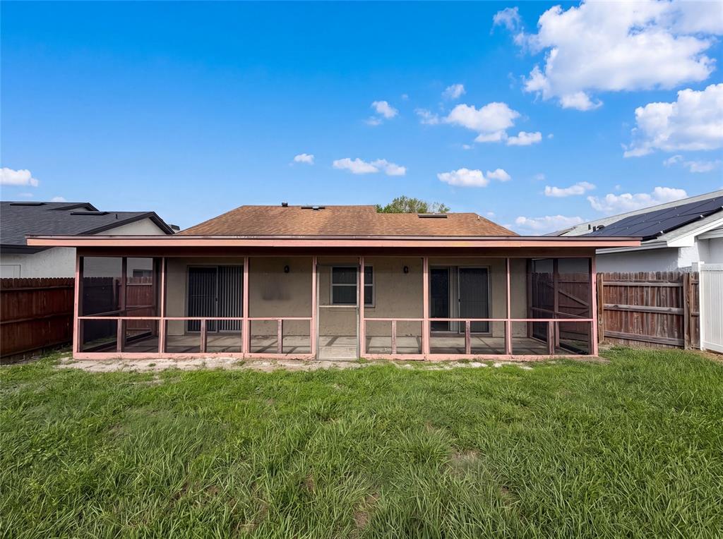 The exterior rear view of a house features a large screened-in porch and a grassy yard — 1393 SAN DIEGO COURT, WINTER SPRINGS, FL