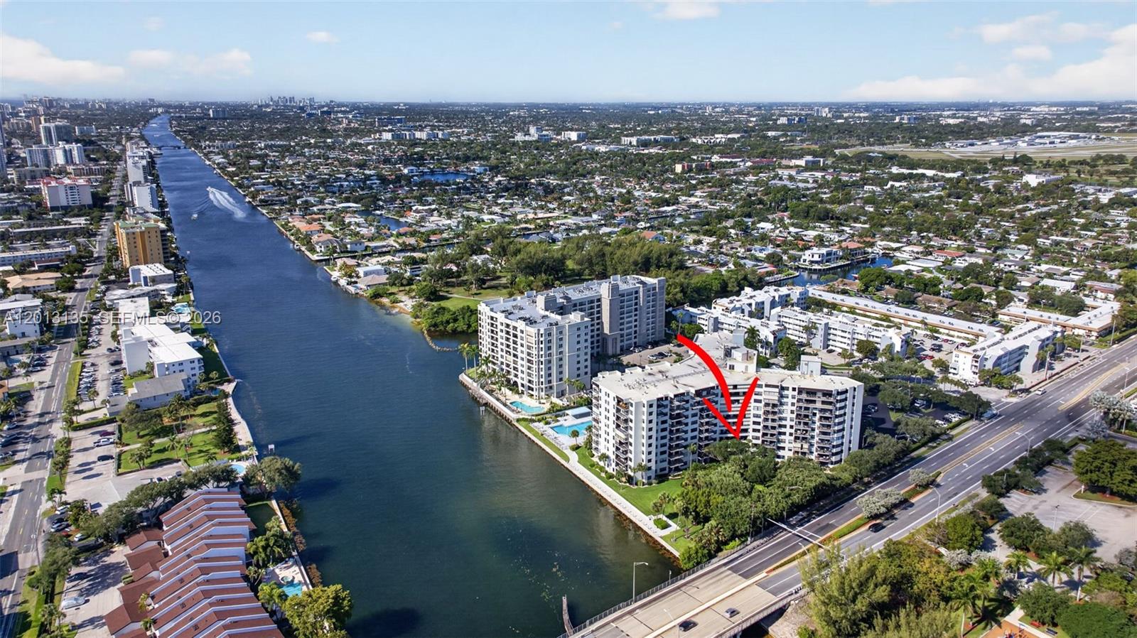 An aerial view shows a multi-story residential building complex situated along a canal — 2900 NE 14th St Cswy # 304, Pompano Beach FL 33062, POMPANO BEACH, FL
