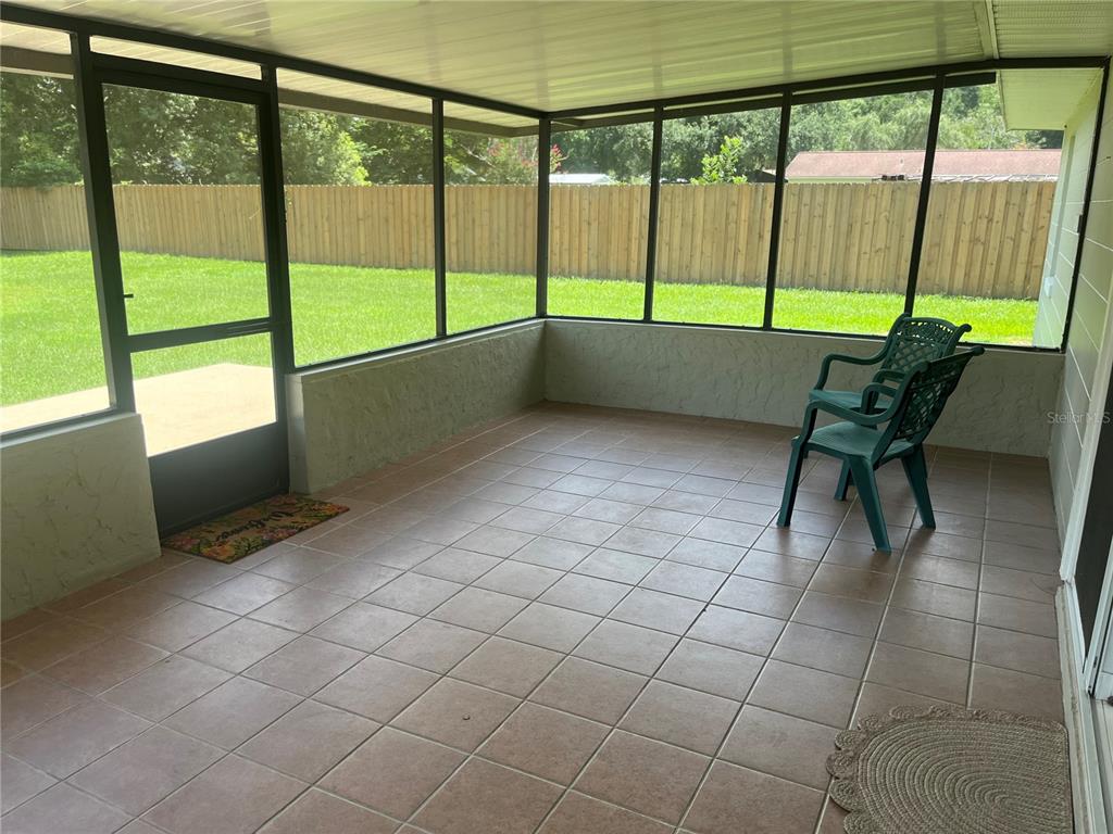 A kitchen with light-colored cabinets, granite countertops, stainless steel appliances, and tile flooring — 5455 NE 22ND AVENUE, OCALA, FL