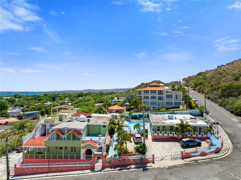 An aerial view of a green multi-story building with a pool and adjacent parking lot — #3 CARR 304, LAJAS, PR