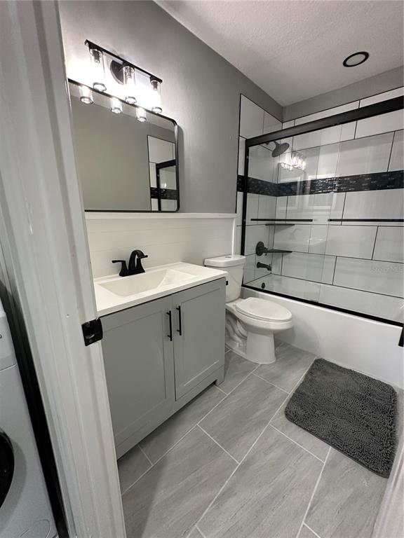 A bathroom features a gray vanity, white subway tile shower, and light gray floor tiles — 460 E BASE AVENUE UNIT 129, VENICE, FL