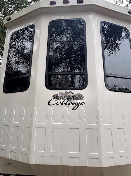 The exterior front of a white Cedar Creek Cottage recreational vehicle features three large windows — 14432 252ND COURT ROAD NE UNIT 140, FORT MC COY, FL