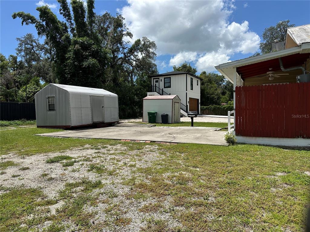 A backyard features a concrete pad, two storage sheds, and a detached two-story garage — 1209 E ELLICOTT STREET, TAMPA, FL