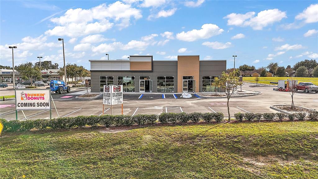 A newly constructed commercial building with a Dunkin' Donuts coming soon sign in the parking lot — 24430 STATE ROAD 44, SORRENTO, FL