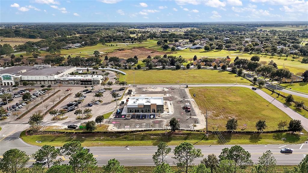 An aerial view shows a commercial building under construction next to a shopping center — 24430 STATE ROAD 44, SORRENTO, FL