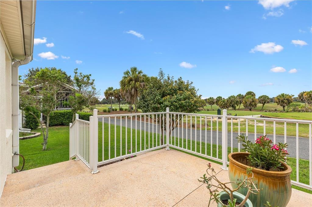 An aerial view shows a suburban house with a tan roof bordering a golf course — 2757 DAY LILY RUN, THE VILLAGES, FL