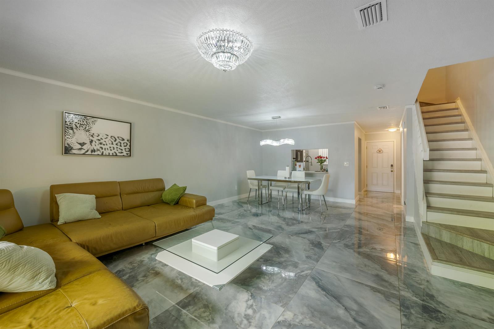 A living and dining area features marble-look tile floors, a tan sofa, and a staircase — 1129 NE 210th Terrace # 210, Miami FL 33179, MIAMI, FL