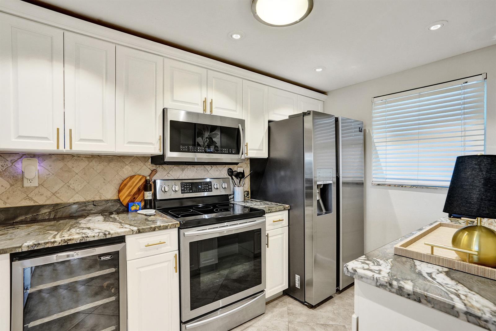 A kitchen featuring white cabinets, stainless steel appliances, and dark marble countertops — 801 S Federal Highway # 301, Pompano Beach FL 33062, POMPANO BEACH, FL