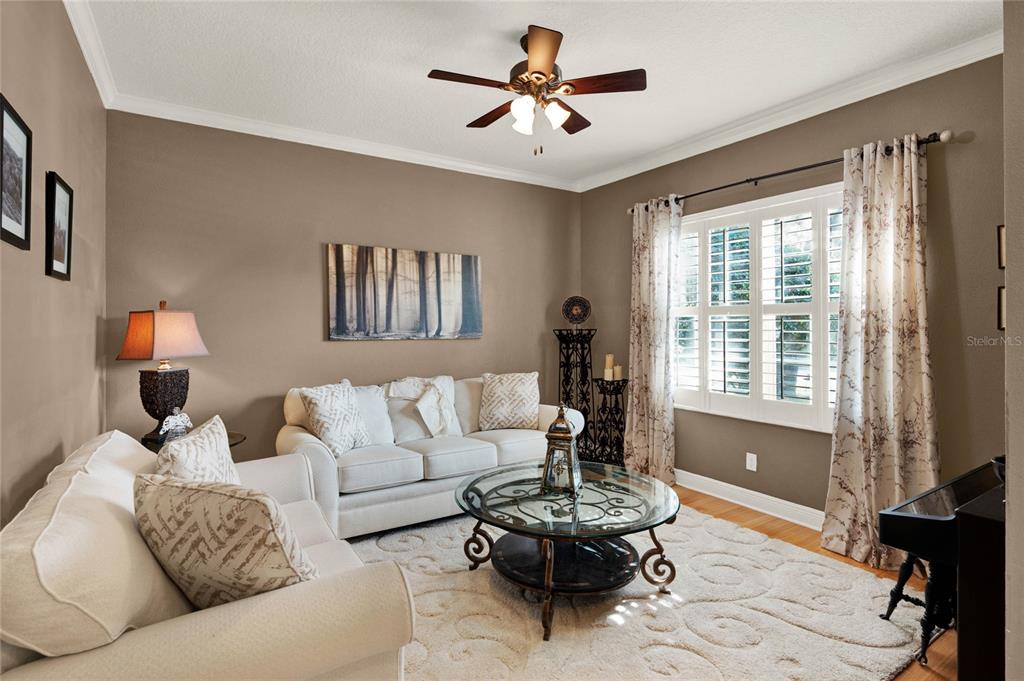 A living room features two white sofas, a glass coffee table, and plantation shutters — 873 GULF LAND DRIVE, APOPKA, FL