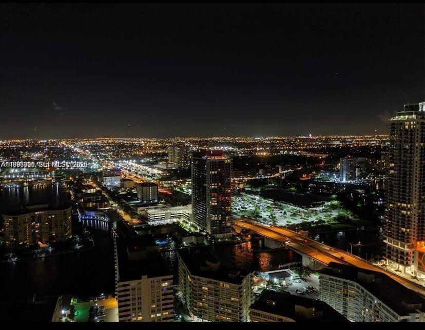 An elevated night view of a city skyline featuring high-rise buildings and illuminated bridges — 1830 S Ocean Dr # 2011, Hallandale Beach FL 33009, HALLANDALE BEACH, FL